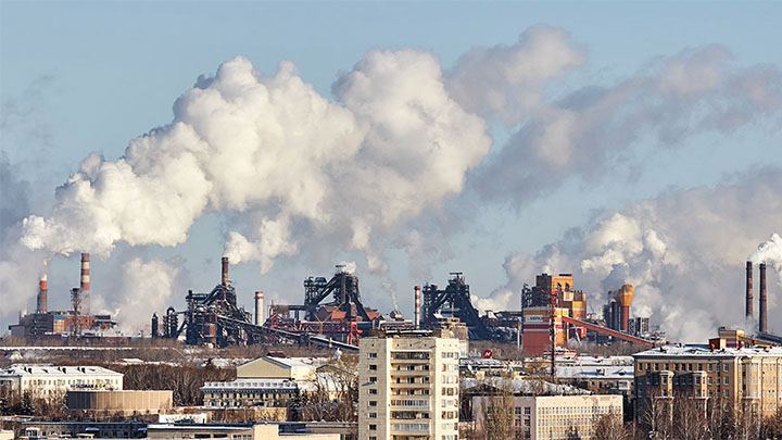 A skyline showing many factory chimneys venting pollution into the air.