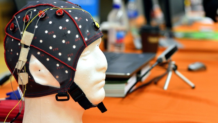 Electroencephalogram (EEG) head cap with flat metal discs (electrodes) attached to a plastic head.