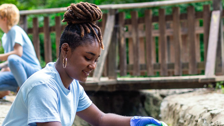 A student volunteering outside.