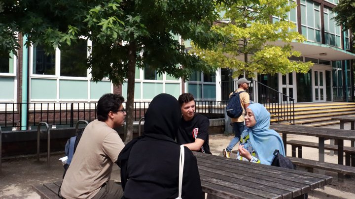 Students sitting at a table and talking.