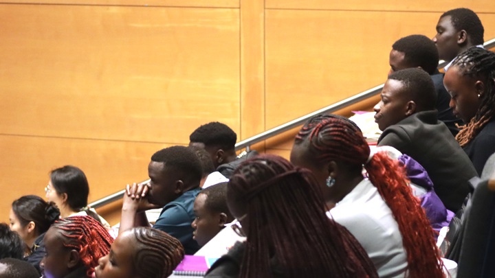 Students sitting in a lecture theatre.