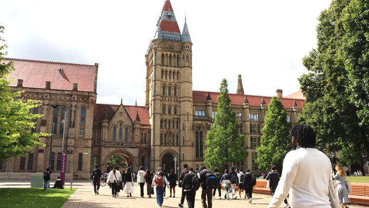 Students walking near Whitworth Hall on the Manchester campus.
