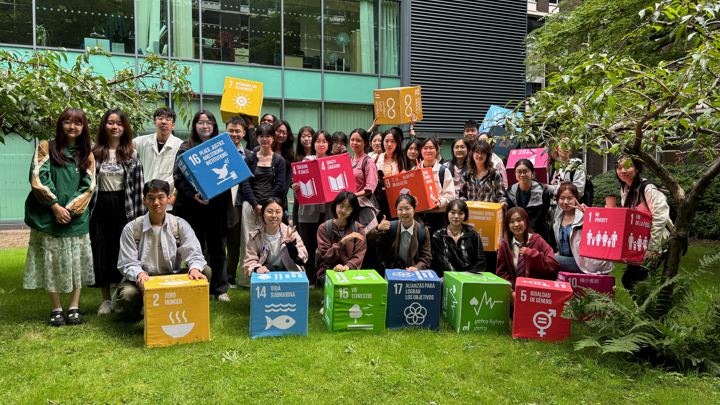 Students holding colourful boxes outdoors.