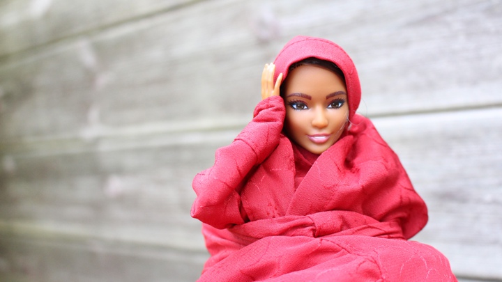 A doll holding a hand to its head.