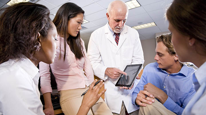 Medical students discussing information with a consultant.